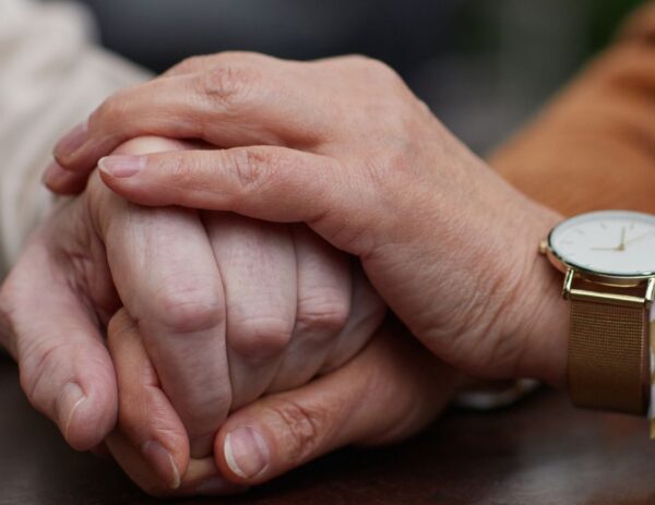 Verzorger houdt hand vast van cliënt