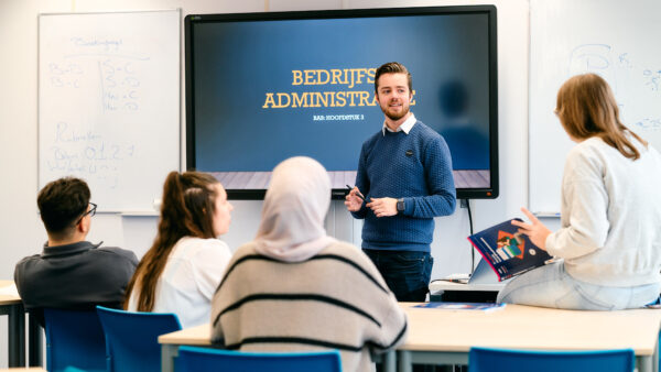 MBO-docent Business Services voor de klas bij een digibord