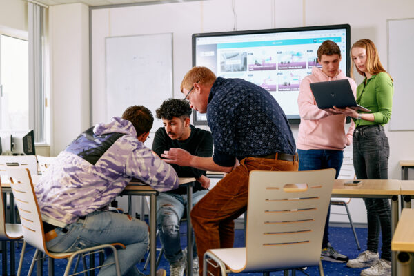 Mbo-studenten retail in een theorielokaal in gesprek met elkaar en met docent