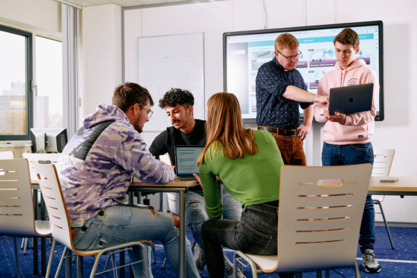 Mbo-studenten Retail/handel in een theorielokaal met elkaar in gesprek.