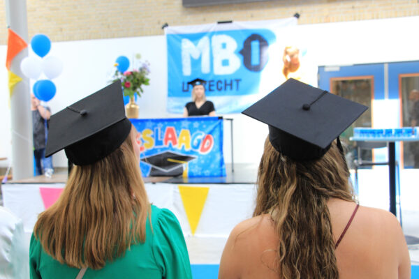 Studenten lopen binnen bij een feestelijke diplomering