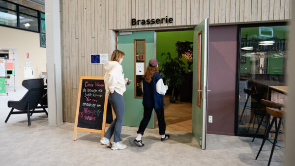 Twee studenten lopen de Brasserie in