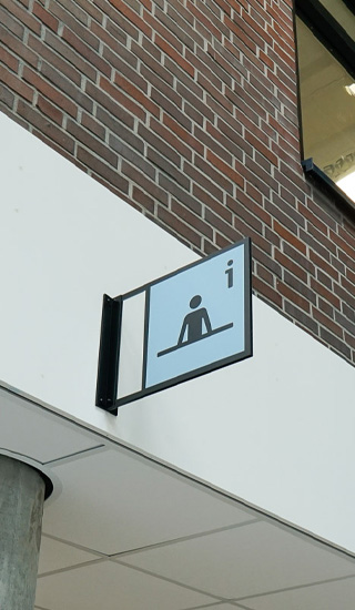 Het icoon voor informatie boven de entreebalie bij MBO Utrecht
