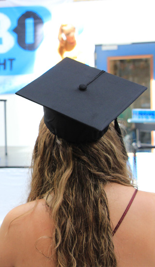 student heeft een afstudeerhoed op in afwachting van haar diploma