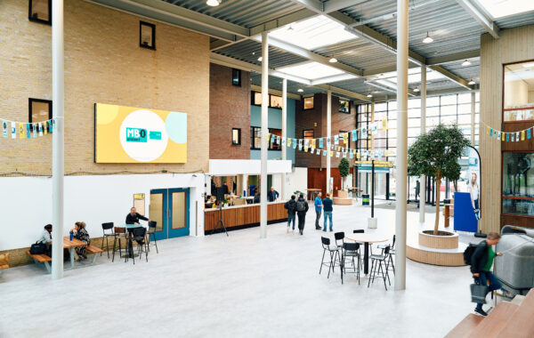 Mbo-studenten en bezoekers bewegen zich vlakbij de ingang van de Onderwijsboulevard