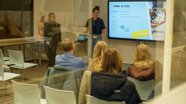 Docent ontvangt bezoekers bij een opleidingspresentatie op de Open Dag