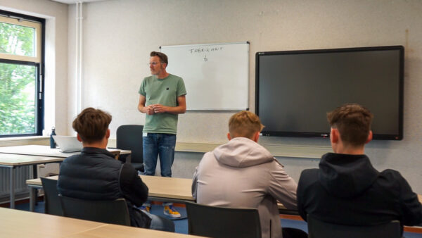 Docent in gesprek met studenten op een meeloopdag