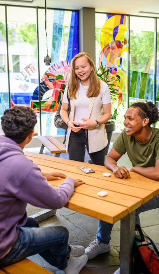 studenten praten met elkaar voor een gekleurde muur