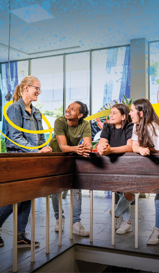 Vier mbo-studenten leunen over een trapleuning en zijn in gesprek met elkaar