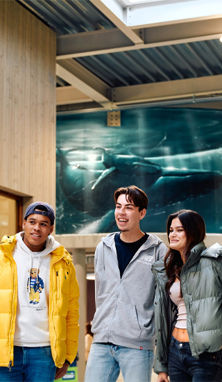 Studenten kijken blij in de wandelgangen op school