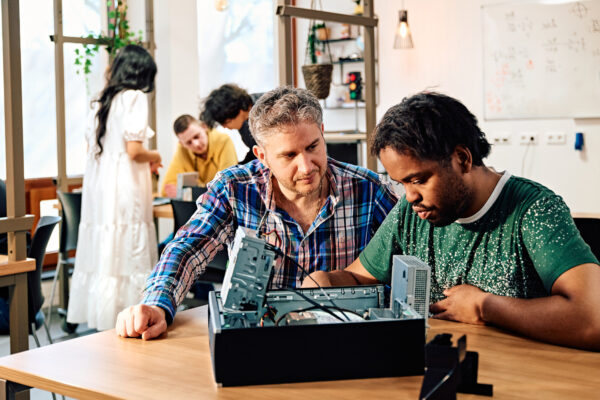 Student ICT krijgt les in hardware van een docent