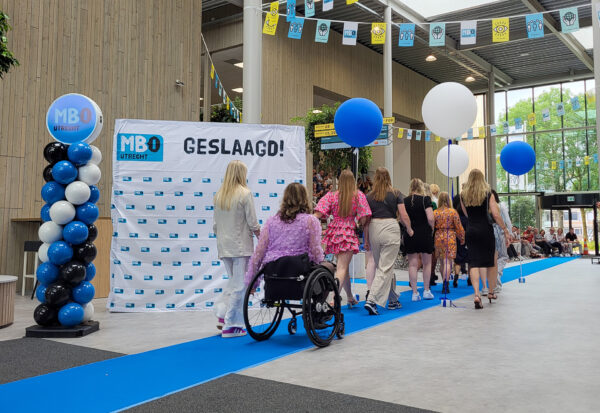 Studenten lopen binnen bij een feestelijke diplomering