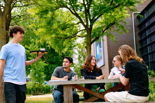 Student horeca serveert koffie op het terras