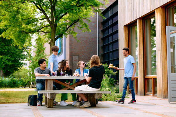 Studenten serveren eten en drinken op het terras van de brasserie